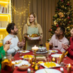 Multiethnic group of happy friends having Christmas dinner together at home together.