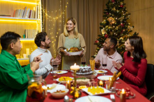 Multiethnic group of happy friends having Christmas dinner together at home together.