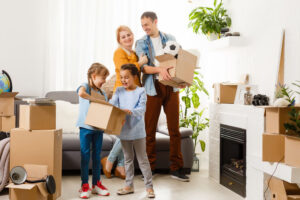 Family with cardboard boxes standing in row at home