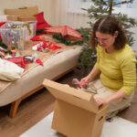 Woman setting aside a small box with holiday decorations