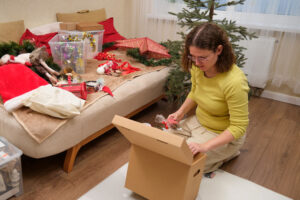 Woman setting aside a small box with holiday decorations